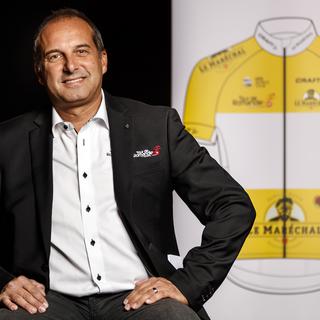 Richard Chassot, directeur du Tour de Romandie, devant le nouveau maillot sponsorisé par Le Maréchal. [Keystone - Valentin Flauraud]