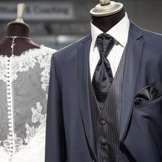 Une robe et un costumes de mariés lors d'une exposition consacrée au mariage. [Keystone - Christian Beutler]