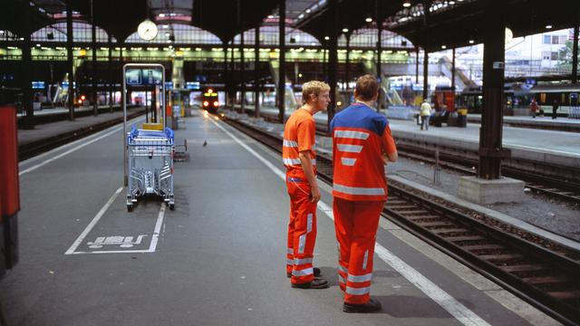 Des employés CFF sur un quai de la gare à Bâle. [Keystone - Martin Rütschi]