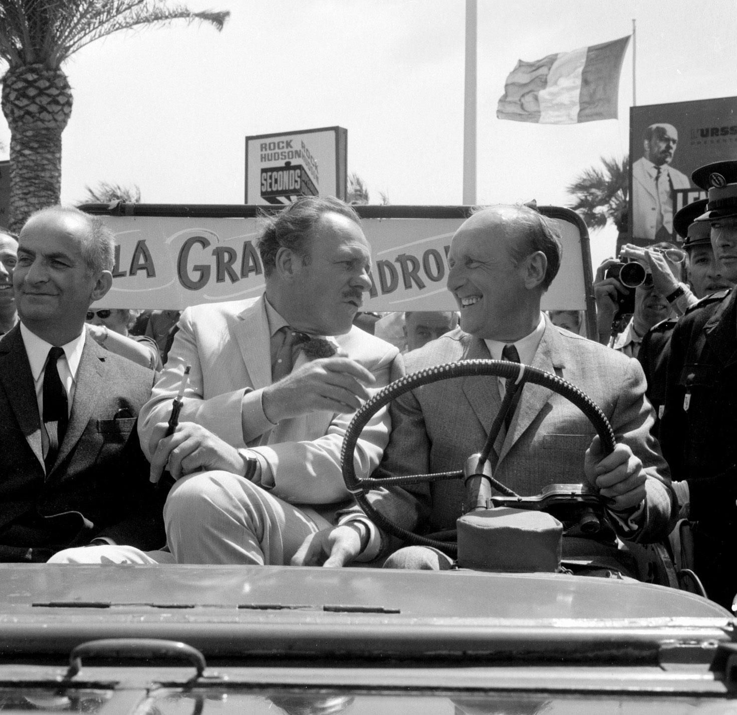 Les vedettes de "La grande vadrouille" Louis de Funès (G), Terry Thomas (C) et Bourvil (D), arrivent au Palais du Festival à bord d'une jeep, le 10 mai 1966 à Cannes. [AFP]