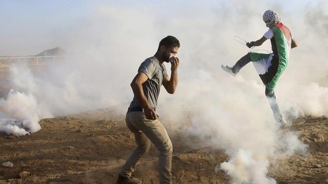 Un manifestant shoote dans un lacrymogène tiré par les troupes israéliennes dans l'est de la bande de Gaza, le 14 septembre 2018. [Keystone - Adel Hana]