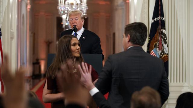 Une stagiaire de la Maison Blanche tente d'enlever le micro des mains de Jim Acosta (de dos) sous le regard du président Trump. [AP - EVAN VUCCI]