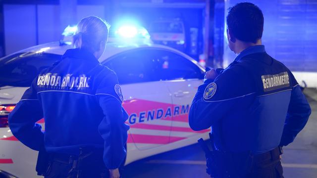 Deux gendarmes vaudois devant leur voiture de patrouille. [Keystone - Laurent Gilliéron]