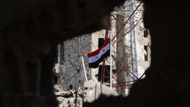 Le drapeau syrien hissé par les forces de Bachar al-Assad dans le centre-ville de Deraa, le 12 juillet 2018. [AFP - Mohamad ABAZEED]