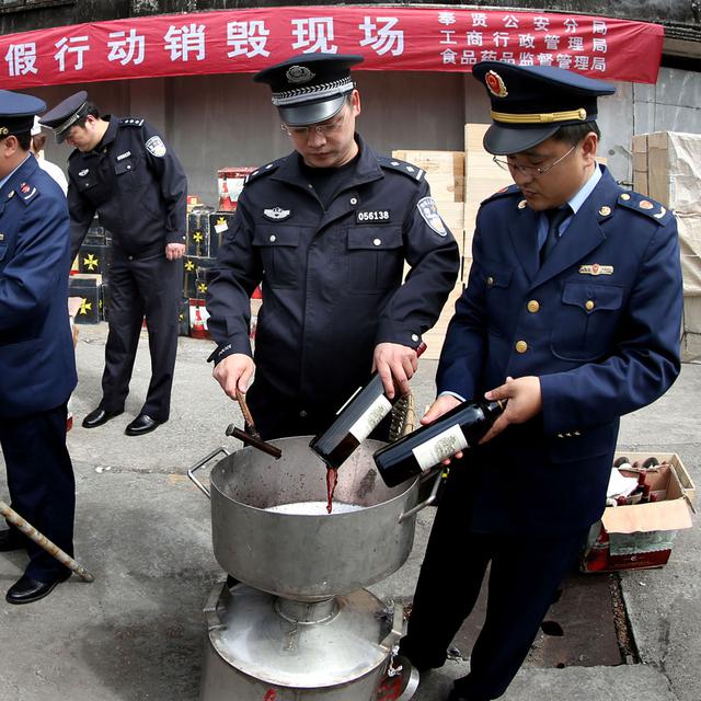 A Shanghaï, la police détruit 3'000 bouteilles de vin de contrefaçon en 2013. [AFP - Fan Jun]
