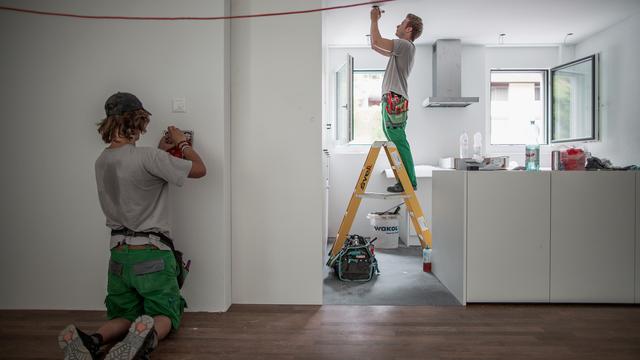 Des apprentis électriciens travaillent dans un nouveau bâtiment (image d'illustration). [Keystone - Gaëtan Bally]