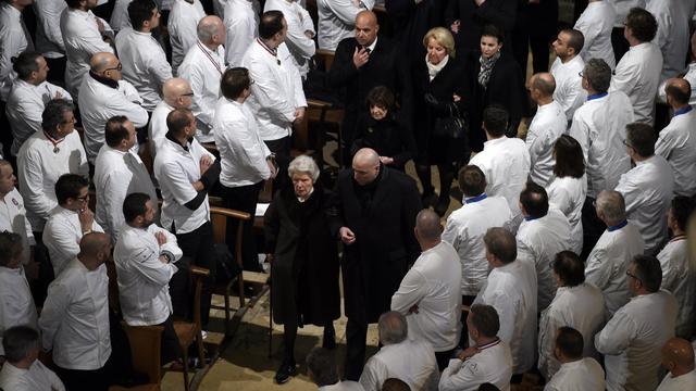 La famille de Paul Bocuse entre dans l'église au milieu des chefs venus lui rendre hommage. [Keystone - PHILIPPE DESMAZES]