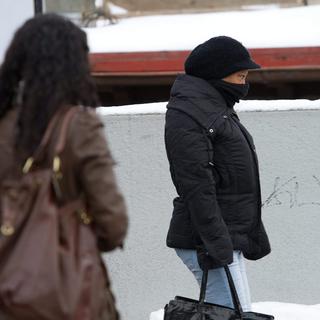 Le froid oblige les gens à se cacher le visage (image d'illustration). [Keystone - Jean-Christophe Bott]