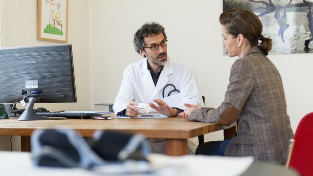 Un médecin lors d'une consultation avec une patiente (photo prétexte). [Keystone - Christian Beutler]