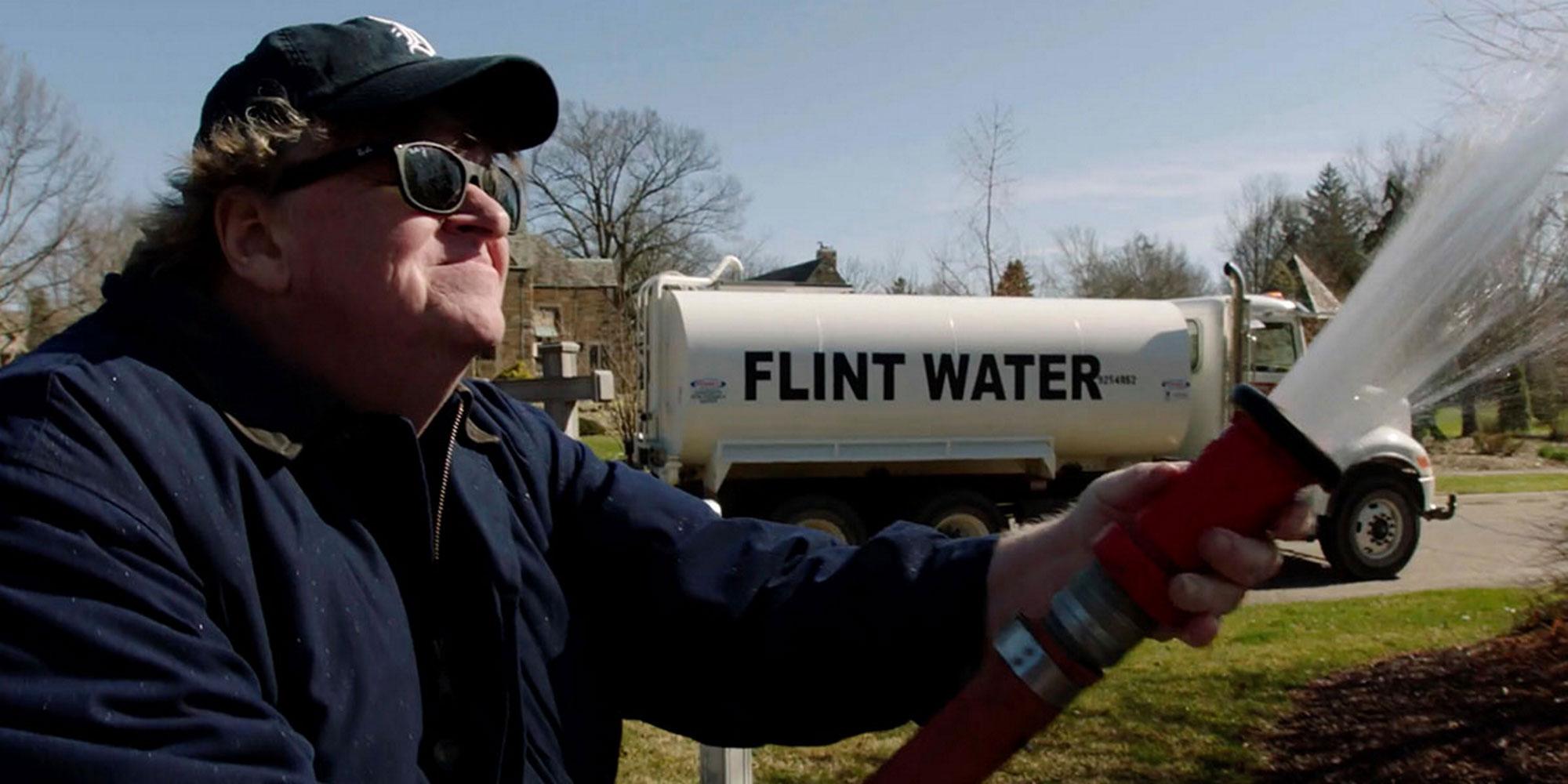 Michael Moore arrose un jardin avec de l’eau plombée provenant de Flint, dans le Michigan. [AFP - Notimex]
