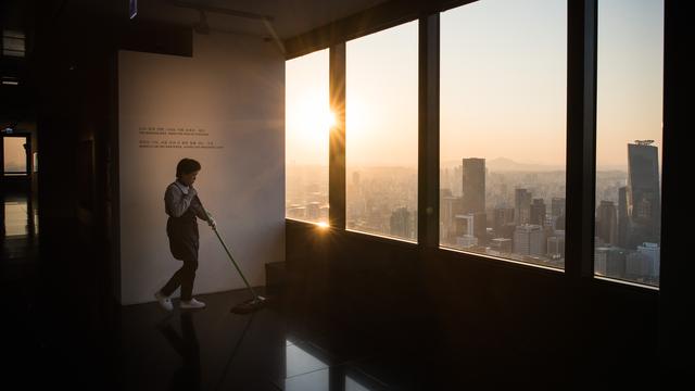 Une employée de nettoyage dans un gratte-ciel de la capitale sud-coréenne Séoul. [AFP - Ed Jones]