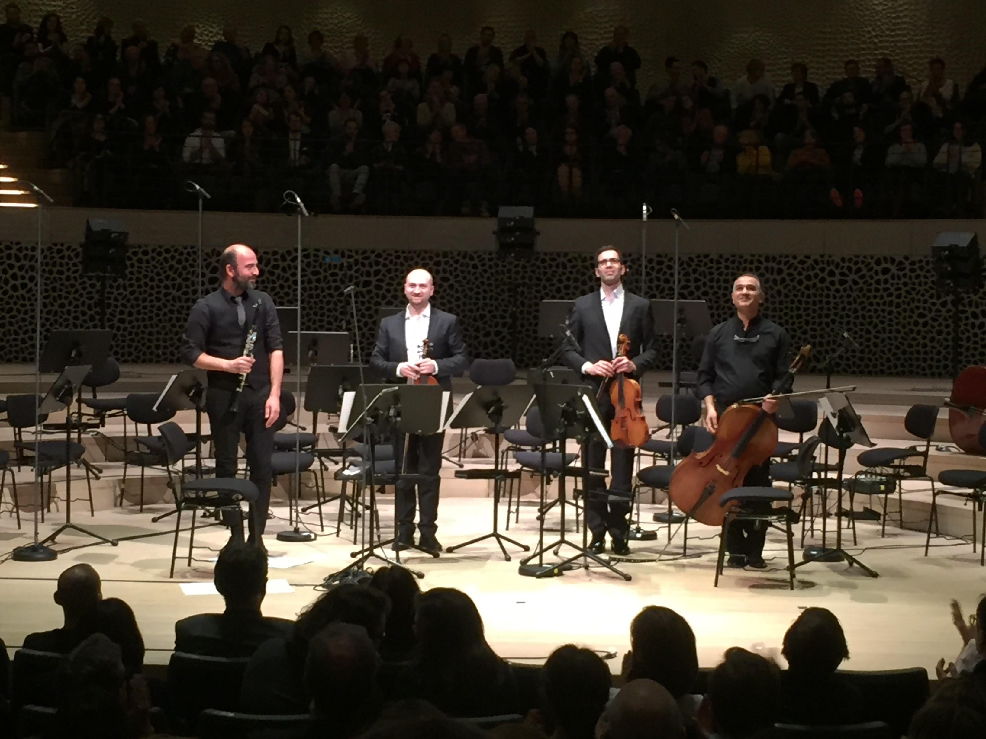 Kinan Azmeh, Jehad Jazbeh, Thaer Eid et Athil Hamdan, musiciens issus du SEPO, sur la scène de la Philharmonie de l'Elbe à Hambourg. [DEDKU/DR - Michael Volker]