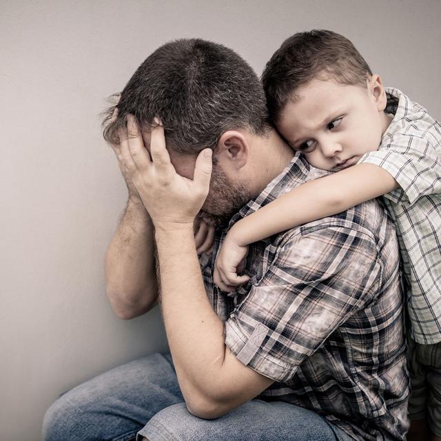 Un père de famille désespéré avec son fils sur le dos. [Fotolia - altanaka]