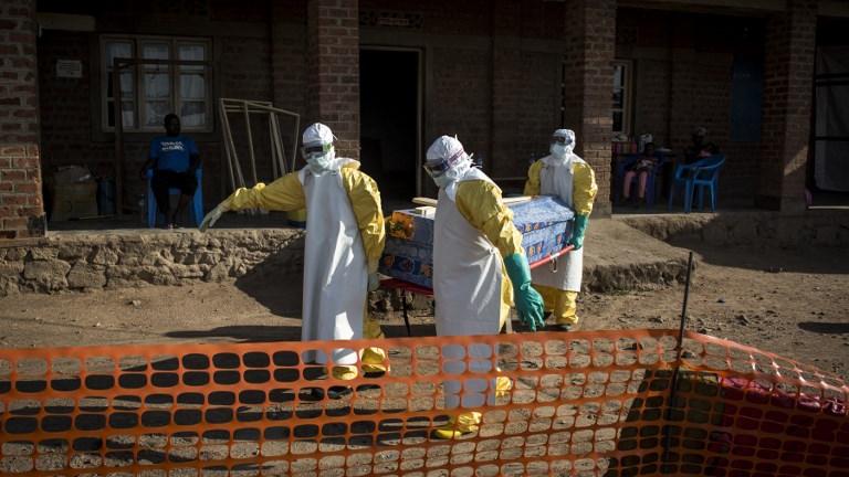 Des médecins portent le corps d'une personne décédée du virus Ebola en RDC. [afp - John Wessels]