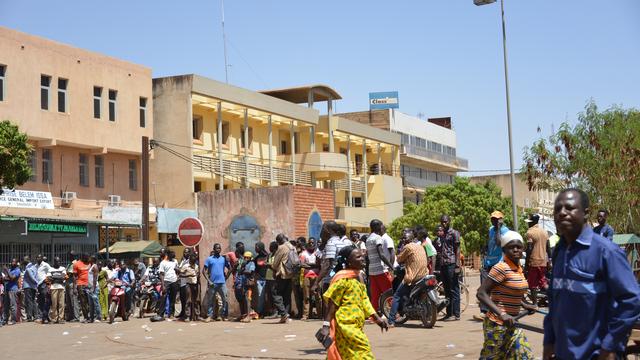 Des passants se regroupant à l'extérieur du QG de l'état-major des forces armées du Burkina Faso, après l'attaque du 2 mars 2018. [AFP - Ahmed OUOBA]