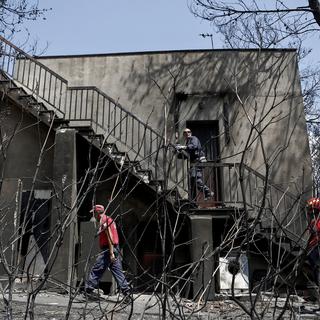 Les équipes de secours recherchent des disparus après les violents incendies qui ont touché Mati, une ville côtière à l'est d'Athènes. [EPA - Yannis Kolesidis]