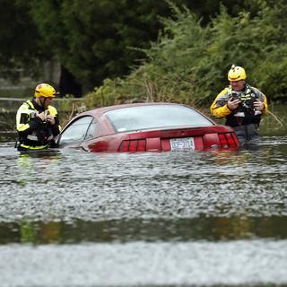 Des secouristes près d'une voiture submergée après le passage de Florence à New Bern. [Keystone - AP Photo/Chris Seward]