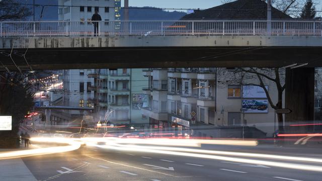 Des voitures passent devant des immeubles en ville de Zurich. [Keystone - Gaëtan Bally]