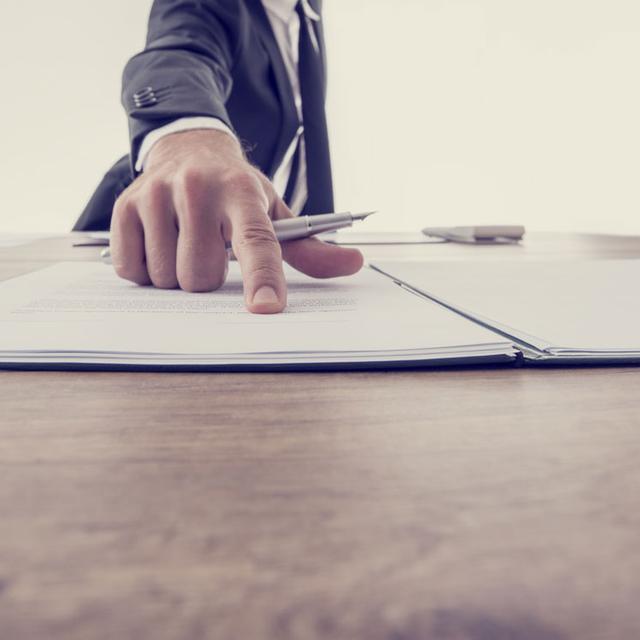 Gros plan sur la main d'un homme incitant une personne à signer un contrat. [Fotolia - Gajus]