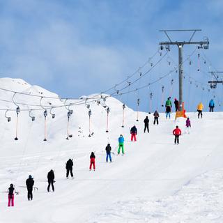 Des skieurs remontent la piste sur un téléski à Verbier. [AFP - Christian Kober]