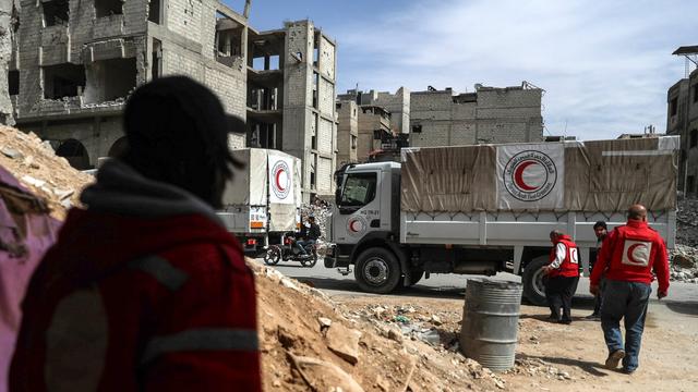 Le convoi humanitaire dans une rue dévastée de Douma. [EPA/Keystone - Mohammed Badra]