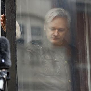 Julian Assange referme une fenêtre de l'ambassade d'Equateur à Londres, après avoir salué des soutiens, en mai 2017. [AP Photo - Frank Augstein]