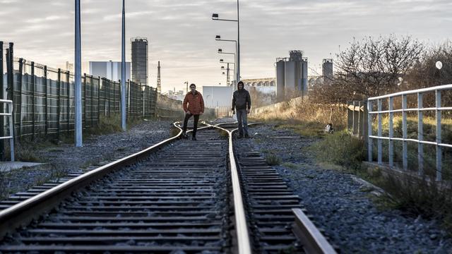 Deux jeunes Afghans sur une voie de chemin de fer à Calais, en décembre 2017. [AFP - Dominika Zarzycka]