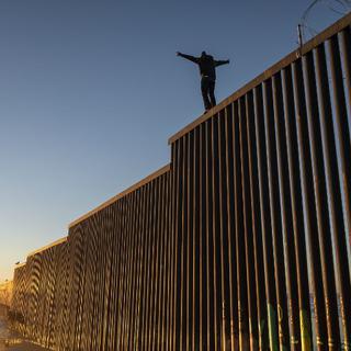 Mardi 11 décembre: un migrant hondurien sur le mur séparant le Mexique des Etats-Unis. [afp - Guillermo Arias]