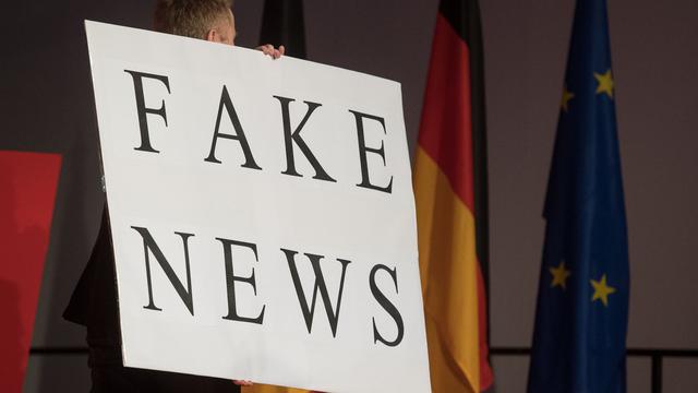 Un homme porte un panneau "Fake News" le 01.03.2017 à Fellbach, en Allemagne, lors d'un meeting de la CDU. [Keystone/DPA - Marijan Murat]