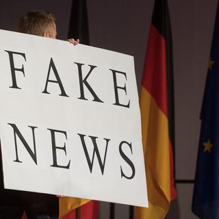 Un homme porte un panneau "Fake News" le 01.03.2017 à Fellbach, en Allemagne, lors d'un meeting de la CDU. [Keystone/DPA - Marijan Murat]