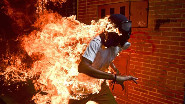 Ronaldo Schemidt a remporté jeudi le prestigieux prix de la photo de l'année au World Press Photo 2018, pour une image d'un manifestant masqué et en flammes prise pendant des émeutes à Caracas. [AFP - Ronaldo Schemidt]