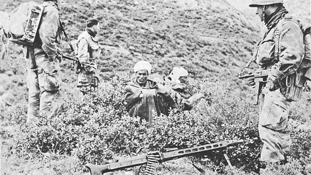 Trois soldats français du 9e RCP en 1958. Assis: deux prisonniers algériens auxquels on a confisqué le fusil-mitrailleur posé au sol.