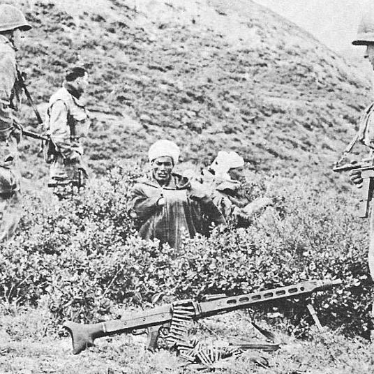 Trois soldats français du 9e RCP en 1958. Assis: deux prisonniers algériens auxquels on a confisqué le fusil-mitrailleur posé au sol.