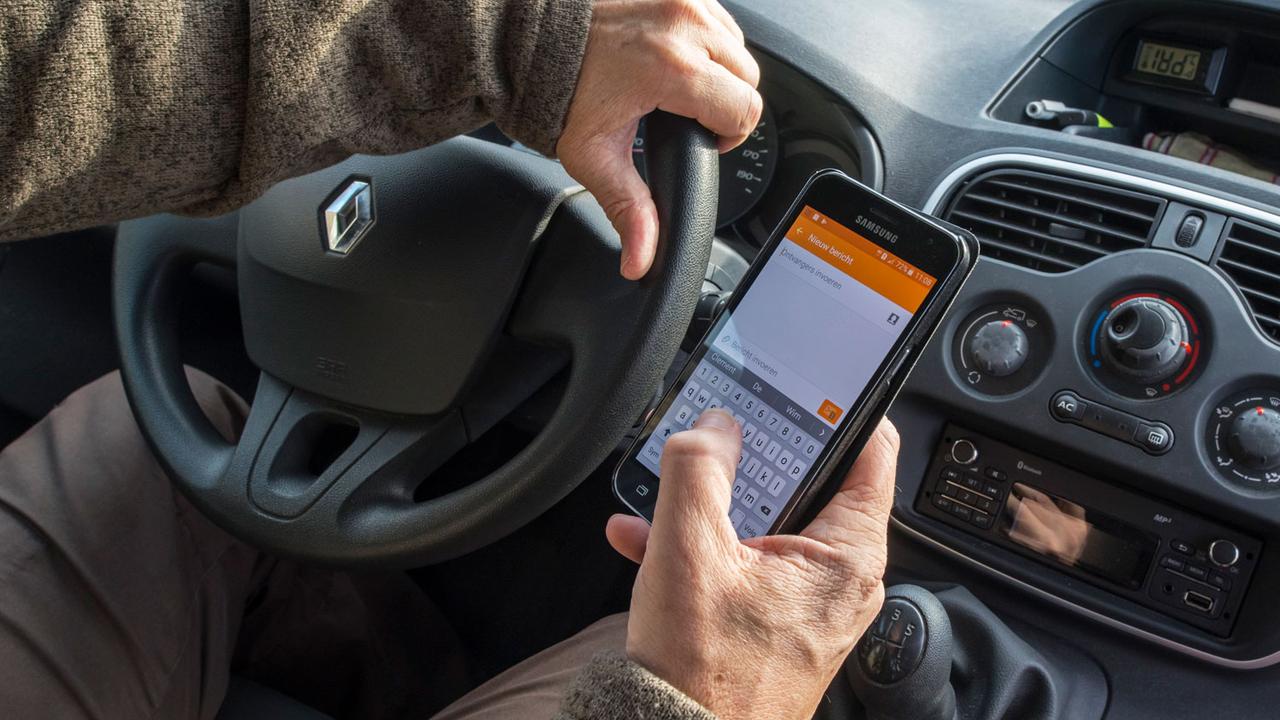 Le prévenu manipulait son smartphone tout en conduisant (image d'illustration). [Belga/AFP - Philippe Clément]