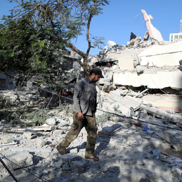 Un Palestinien marchant près des ruines d'un bâtiment détruit par des frappes israéliennes. [Reuters - Suhaib Salem]