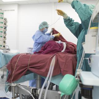 Des médecins préparent un patient à une intervention chirurgicale. [Keystone - Gaetan Bally]