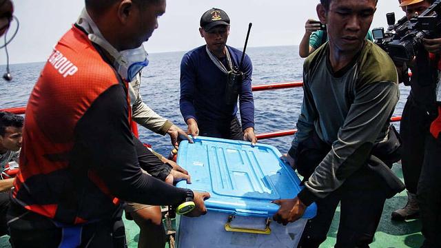 Des sauveteurs ramènent une des boîtes noir dans une caisse en plastique,ce 1er novembre 2018 au large de l'île de Java. [EPA - PRADITA UTAMA]