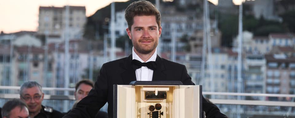 Le réalisateur Lukas Dont avec son prix "Caméra d'Or" pour son film "Girl" au Festival de Cannes 2018. [AFP - Anne-Christine Poujoulat]