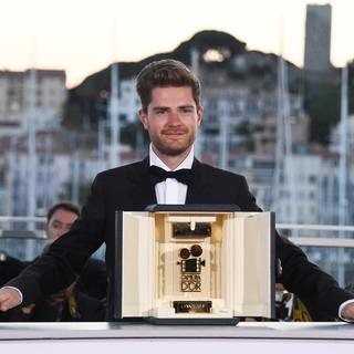 Le réalisateur Lukas Dont avec son prix "Caméra d'Or" pour son film "Girl" au Festival de Cannes 2018. [AFP - Anne-Christine Poujoulat]