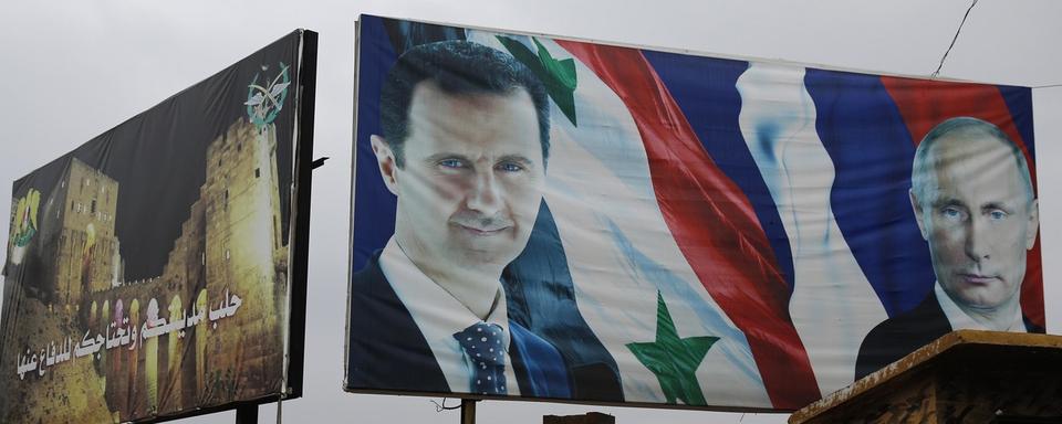 Les présidents syrien Bachar al-Assad et russe Vladimir Poutine représentés sur un panneau géant à Alep, le 18 janvier 2018. [Keystone - Hassan Ammar]