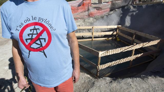 Un manifestant devant les fouilles du chantier du pylône 164 de la ligne THT Chamoson-Chippis en Valais, le dimanche 14 octobre 2018. [Keystone - Laurent Gillieron]