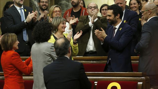 Le nouveau président du parlement catalan Roger Torrent (à droite en bleu avec une barbe), félicité après son élection. [AP Photo - Manu Fernandez]