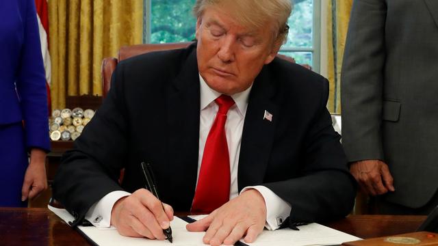 Donald Trump signant le décret mettant fin à la séparation des familles de migrants. [Reuters - Leah Millis]
