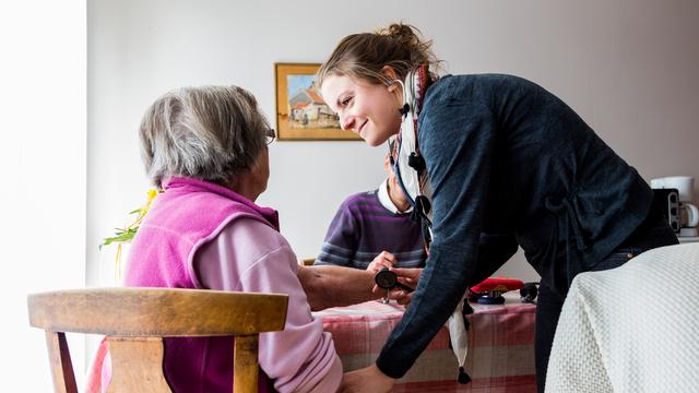 Une aide à domicile s'entretient avec une patiente. [afp - Garo Phanie]