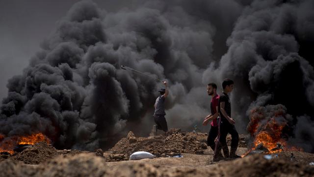 Des Palestiniens durant une manifestation à la frontière de Gaza, lundi 14 mai, jour de l'inauguration de l'ambassade américaine à Jérusalem. [keystone - LUCA PIERGIOVANNI]