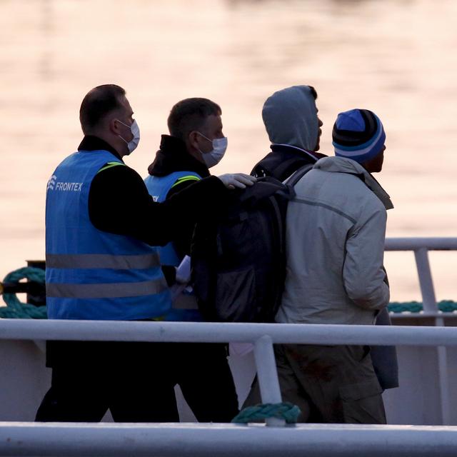 Des gardes-frontière de l'agence européenne Frontex escortent des migrants. [Reuters - Giorgos Moutafis]