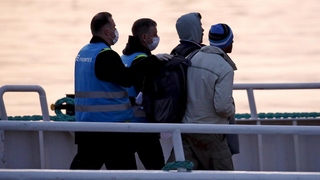 Des gardes-frontière de l'agence européenne Frontex escortent des migrants. [Reuters - Giorgos Moutafis]