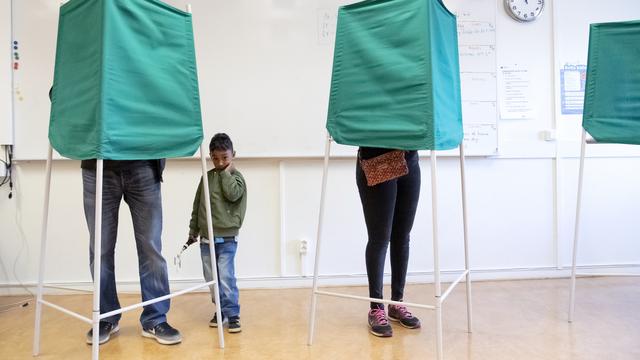 Citoyens suédois remplissant leur bulletin dans un bureau de vote de Malmö dimanche, à l'occasion des législatives. [EPA/Keystone - Johan Nilsson]