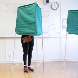 Citoyens suédois remplissant leur bulletin dans un bureau de vote de Malmö dimanche, à l'occasion des législatives. [EPA/Keystone - Johan Nilsson]