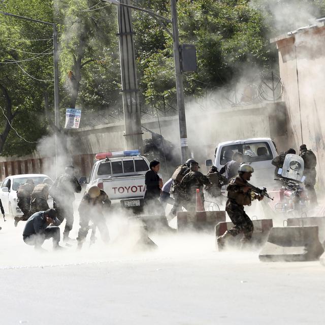 Des forces de sécurité fuient le lieu du second attentat-suicide à Kaboul, ce 30 avril 2018. [keystone - Massoud Hossaini]